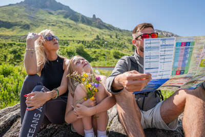 Famille regardant une brochure d'activité à Tignes